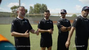 Destination: European Nights TV show screenshot 1: Four men in soccer uniforms stand on a field talking.