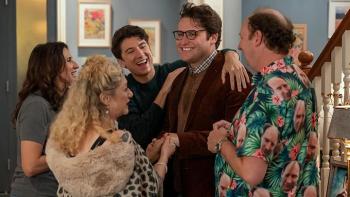 Dinner with the Parents TV show screenshot: A man stands with his parents, brother and grandmother excitedly gathering around to listen