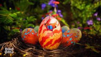 Dino Pops TV show screenshot 3: A brightly colored orange and yellow stripped egg cracks open with a dinosaur baby peeking out.