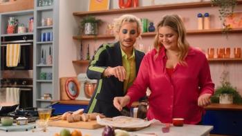 Dish It Out TV show screenshot 2: Ramsay and guest Frankie Grande stand behind the kitchen counter, sprinkling salt onto slabs of garlic bread.
