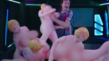 Do You Want to See a Dead Body? Series: A man stands inside a darkened trailer, surrounded by rubber sex dolls; he is smiling gleefully. 