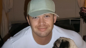 Don't Date Brandon TV show screenshot 3: Brandon Johnson wearing baseball cap and smiling while holding smal dog.