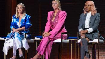 Three female judges in boldly colored suits perch on stools