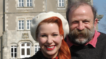 Escape to the Chateau TV show screenshot 2: Close up of Angel in white hat stands left of Dick in front of chateau. 