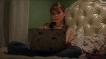 Escaping Twin Flames TV show screenshot 1: Ex-member Marlee sits on her bed, staring into her laptop.