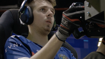 Esports World Cup: Level Up TV show screenshot 1: A male gamer with earphones sits in driver's chair of racing game.