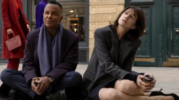 Étoile TV show screenshot 1: Genvieve and Raphael sit on the floor of a rehearsal room, looking at something off-camera that's dismaying. 