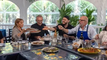 Family Restaurant TV Show: host Andrew Zimmern eats at a table with 3 Italian American restaurant owners
