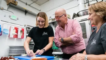 Family Restaurant TV Show: host Andrew Zimmern learns to make a recipe from two white women chefs