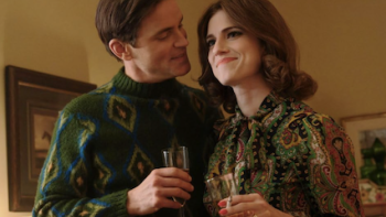 Fellow Travelers TV show screenshot 3: An older Hawks hugs Lucy during a toast. 