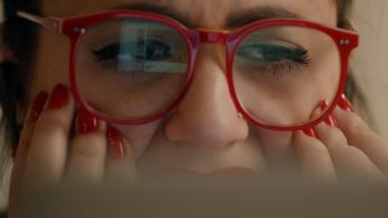 Follow This Series: A woman in red glasses puts her hand to her face in horror when she sees something on a computer screen. 