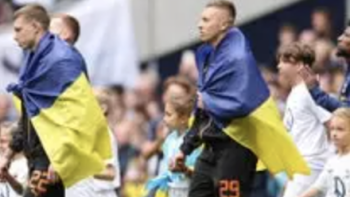 Football Must Go On TV show screenshot 2: Players take the field wearing blue and yellow flags. 
