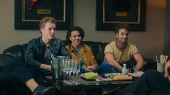 Freeks TV show screenshot 3: Three Freeks band members sit on the couch with sushi and champagne sitting in front of them. 