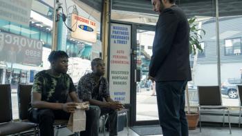 Full Circle TV show screenshot 3: a man addresses two Ghanian immigrants in a storefront