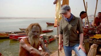 The Ganges with Sue Perkins: Sue Perkins watches a man rub water and ashes into his skin on the bank of the Ganges.