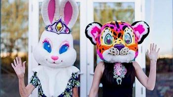 Glitter and Greed screenshot 3: Two people stand in front of an office building wearing oversized bunny and leopard heads based on Frank characters.