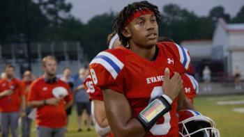 God. Family. Football TV show screenshot: A young black man looks into the horizon while pulling down his football shirt.