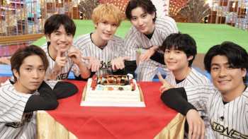 Golden SixTones TV show screenshot 1: Band members in baseball jerseys sit around cake on set. : The 