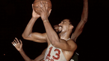 Goliath 2023 screenshot 1: Wilt Chamberlain wears red and white number 13 jersey as he plays the ball on the court.