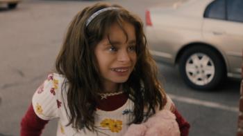 Good American Family TV show screenshot 1: Natalia is seen outside in a parking lots, smiling; she looks off-camera at someone or something