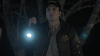 Good Cop/Bad Cop screenshot 3: A young Officer Hank Hickman shines a flashlight at something.