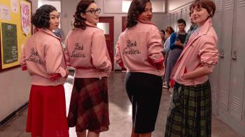 Grease: Rise of the Pink Ladies TV show: 4 Pink Ladies wear satin jackets and turn toward the camera. They stand in a high school hallway.