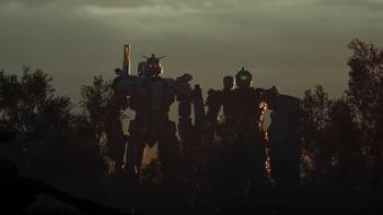 Gundam: Requiem for Vengeance TV Show: Two large gundam robots with red and green eyes stand ready between a group of trees.