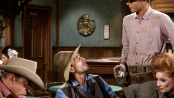 Gunsmoke screenshot 3: A cowboy talks to Chester Goode at table with Matt Dillon and Kitty Russell.