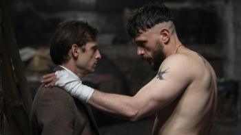 Half Man screenshot 1: Jamie Bell and Richard Gadd. Bell wears a brown jacket and white shirt. Gadd, shirtless, wears white fabric around his hands.