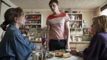 Half Man screenshot 3: Neve McIntosh, Mitchell Robertson, and Marianne McIvor. Robertson stands at a kitchen table as the other two sit around it.