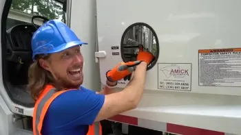 Handyman Hal TV: Handyman Hal in blue hard hat and orange vest smiling as he operates a truck lever.