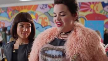 Heathers TV Series: A teen in a ostrich feather coat looks contemptuously at someone off-camera; another girl looks admiringly at her. 