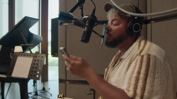 Hitmakers TV show screenshot 2: A songwriter sings into microphone while holding smart phone. 