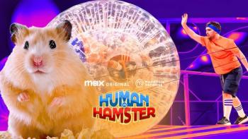 Human Vs. Hamster TV show screenshot: A hamster stand in front of a man in an orange shirt