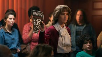 Hysteria! TV show screenshot 1: Mrs. Whitehead is standing amongst neighbors and looking stern while holding up a flyer with a pentagram on it. 