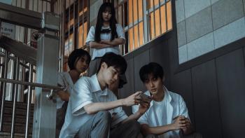 If Wishes Could Kill TV show screenshot 1: A group of high schoolers stand or sit in a stairwell, gathered around a phone and looking concerned