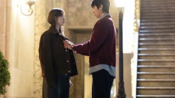 In Your Radiant Season TV show screenshot 1: Lee Sung-kyung and Chae Jong-hyeop. Chae wraps a dark coat around Lee’s shoulders.