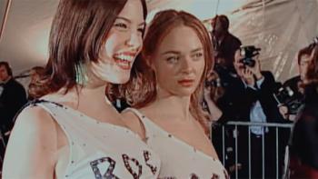 Liv Tyler and Stella McCartney pictured standing together, surrounded by paparazzi, at an event in the 1990s. 