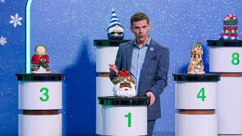 Is It Cake? Holiday TV Show screenshot 1: host Mikey Day slices into a Santa Claus cake on a pedestal