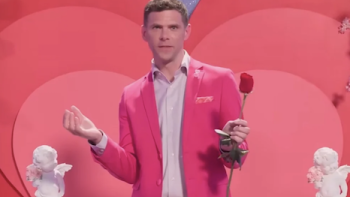 Is it Cake? Valentine's TV show screenshot 1: Mikey Day wearing a bright pink jacket holding a rose.