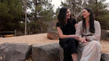 It's OK to Ask Questions: Two women smile and cuddle as they are interviewed in a forest setting