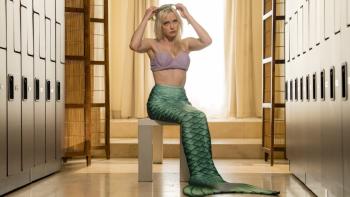 It's Florida, Man. TV show screenshot: A woman dressed as a mermaid sits on a bench in a locker room.
