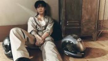 Jung Kook: I Am Still TV show screenshot #3: Jung Kook sits on the floor next to two motorcycle helmets