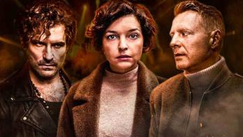 Two men stand on either side of a woman. They all look intense, a bit dirty and wear coats and layers. The men look at the woman and she stare forward