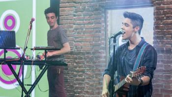 Kally's Mashup TV show screenshot 2: A young man is singing into a microphone while playing guitar.