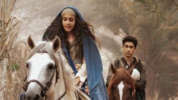 Kevin Costner Presents: The First Christmas TV: Mary rides a white horse while and Joseph rides a brown one in the background, carrying baby Jesus.