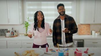 Kids Pick The President screenshot: Mia Burleson and her dad Noah Burleson look at the camera in their white kitchen, backing election-themed cookies.