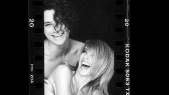 Kylie TV show screenshot 3: Black and white photo of Michael Hutchence hugging Kylie Minogue and smiling.