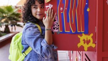 La flor mas bella/The Most Beautiful Flower TV show screenshot 4: A curly-haired Latina teen peeks from behind a school locker door.