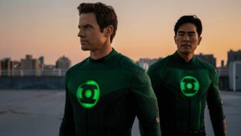 Lanterns: Two Lanterns in Green Lantern costumes with glowing green insignias on the chest are seen against a cityscape at sunset